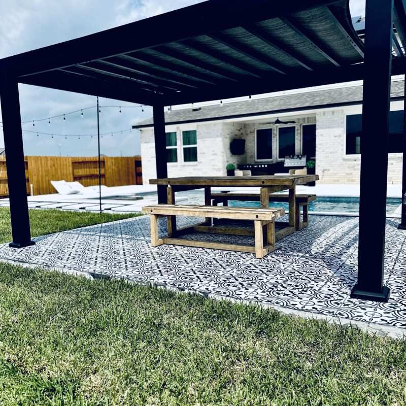 Black pergola beside a finished pool deck